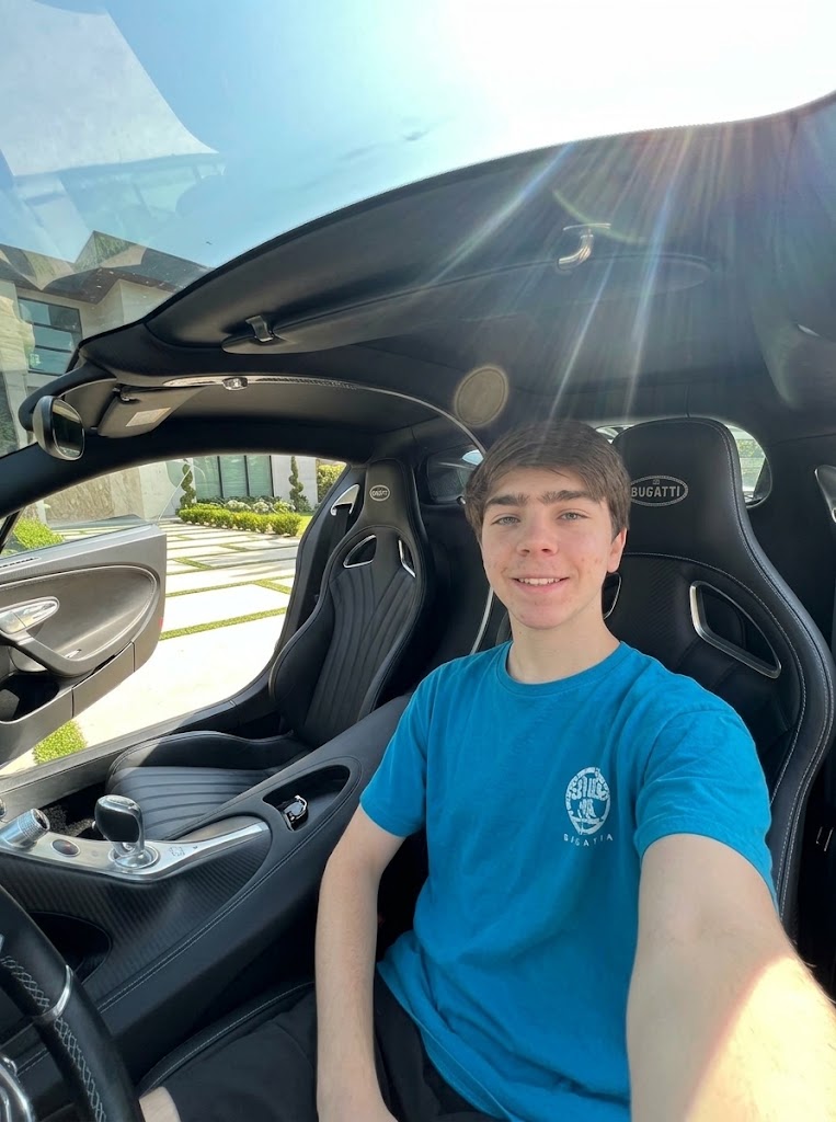 Ethan, standing near a very expensive car